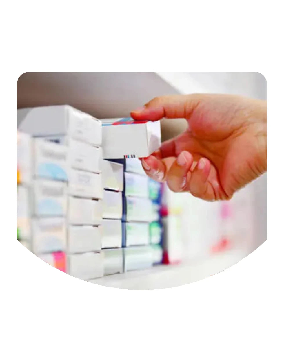A close-up of a hand reaching for a small white medicine box from a shelf filled with similar boxes, shown within a rounded white frame  in intervet UAE